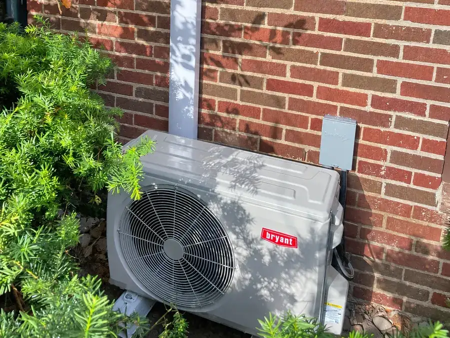 A Bryant ductless outdoor unit installed beside a brick wall