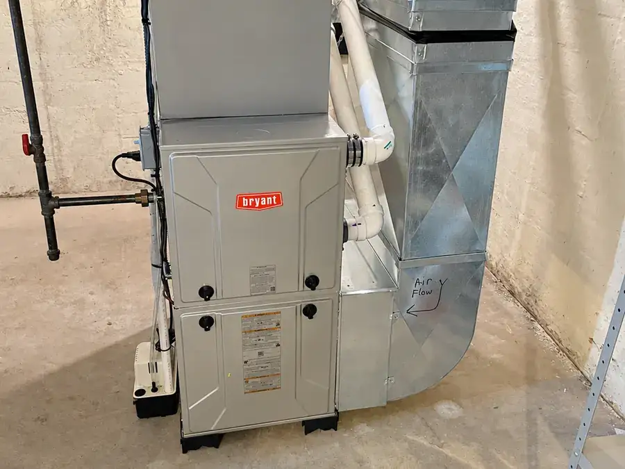 A newly installed Bryant furnace connected to fabricated sheet-metal plenum ductwork in a basement